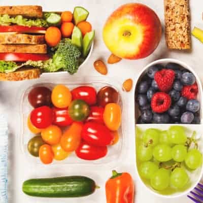 healthy vegan travel meal with sandwich, fruits, and vegetables