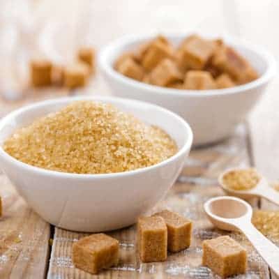 brown sugar crystals and cubes in bowls