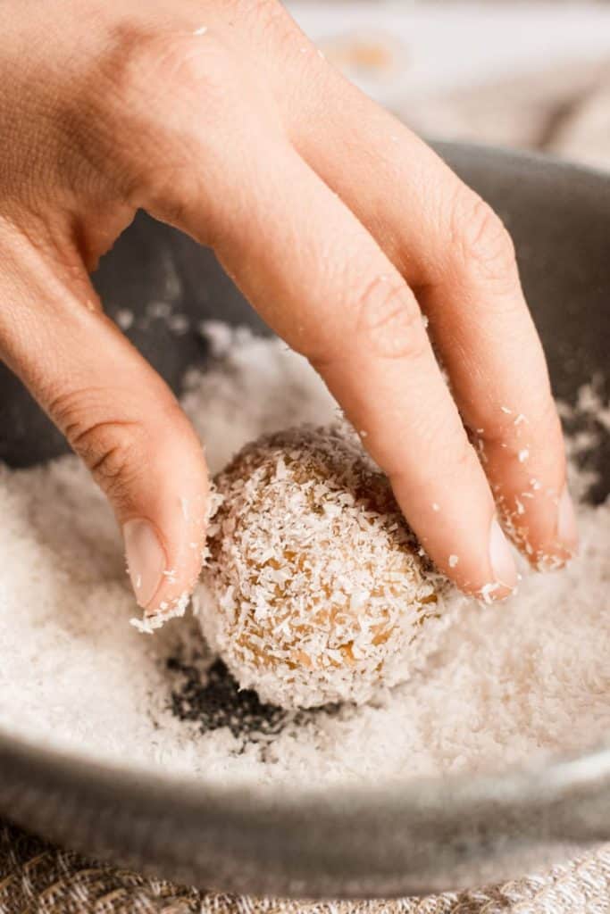 coating the peanut butter balls in shredded coconut