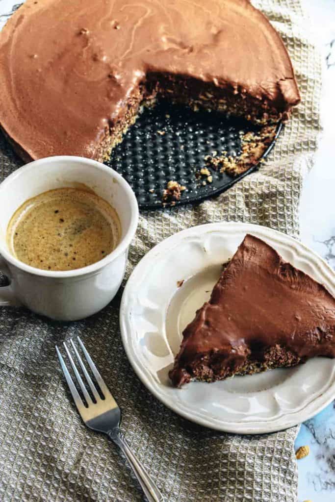 overhead view of raw chocolate cake whole with slice on a plate