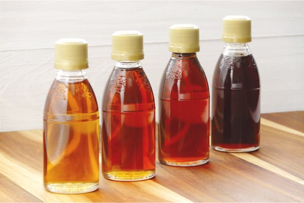 four bottles of vegan pure maple syrup in different grades