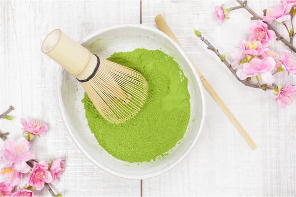 ceremonial grade matcha tea powder in bowl with cherry blossoms
