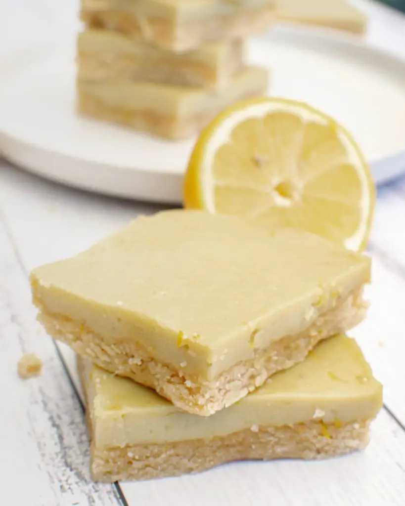 stacked almond flour vegan lemon bars with fresh lemons