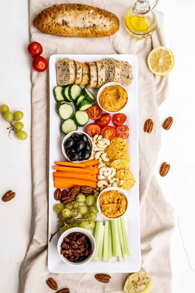 overhead view of vegan grazing platter and snack tray with dips and hummus