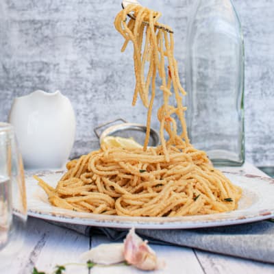 vegan roasted red pepper pasta on plate being eaten using a fork