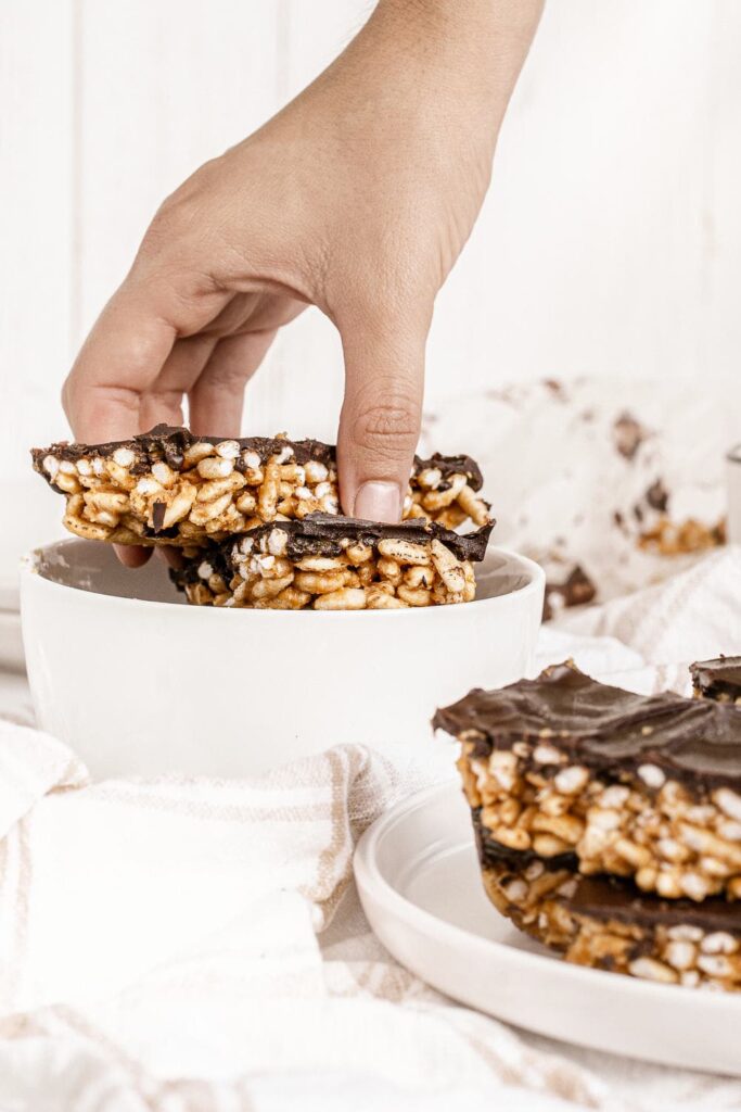 hand grabbing chocolate covered puffed rice bar square