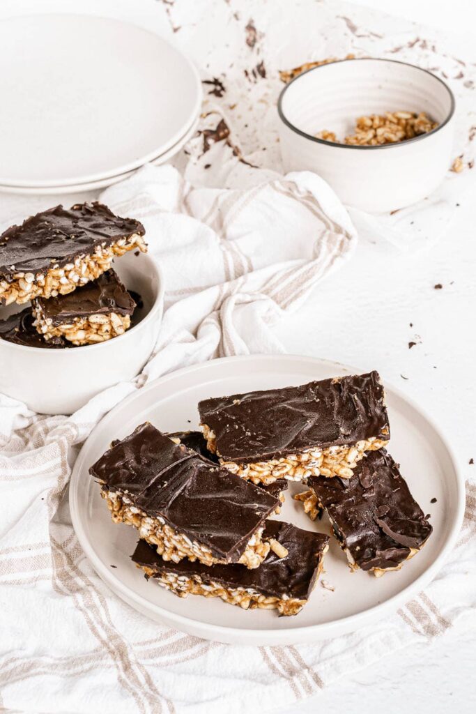 overhead view of chocolate peanut butter puffed rice bars cut into squares on plate
